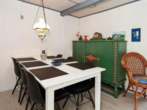 海耶斯4 person holiday home in Hejls的一间带桌椅和绿色橱柜的用餐室