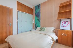 武汉【路客】武汉市江岸区·大智路·路客精品公寓·00189640的卧室配有白色的床和木制橱柜。