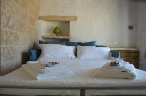 科里利亚诺多特兰托Masseria Costa的一间卧室配有带毛巾的床