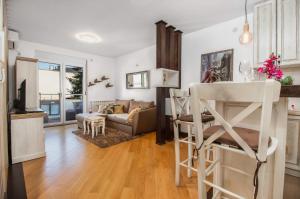 克拉古耶瓦茨Luxury apartmani kg的厨房以及带白色墙壁和木地板的客厅。