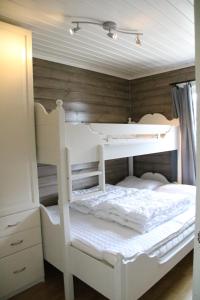 VossestrandMyrkdalen Resort Nedre Byggardslii apartment的配有木制墙壁的客房内的一张白色双层床