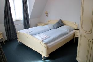 瓦尔拉夫施万祖姆诺恩酒店的客房内的白色床和蓝色床单