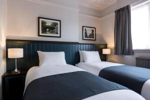 沃特福德南十字旅馆的酒店客房设有两张床和窗户。