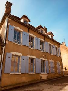 特雷尼L'auberge de Treigny的一座带蓝色百叶窗的古老建筑