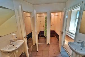 塔林The Monks Bunk Hostel & Bar的浴室配有2个盥洗盆和步入式淋浴间。