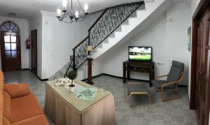 埃尔博斯克CASA MARIA LUISA的带沙发和电视的客厅以及楼梯。