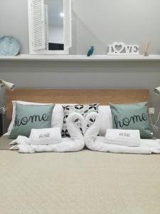 卡尔塔尼塞塔Vacanze HOME的一张带枕头的白色床和毛巾动物
