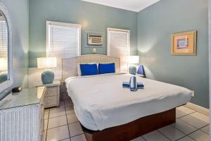 基韦斯特白色旅馆的一间卧室配有一张带蓝色枕头的大床