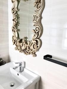 贝尔维尔Posto Al Sole - IL Bacio的浴室设有水槽和墙上的镜子