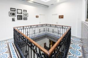 塞维利亚room00 Salvador Hostel的白色房间的一个螺旋楼梯,墙上有艺术作品