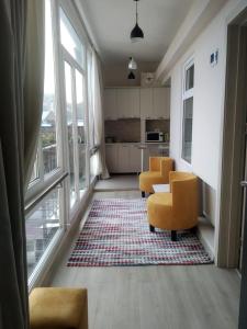 第比利斯City Center Apartment的一间带两张黄色椅子的客厅和一间厨房