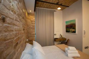 圣贝内代托-德尔特龙托AL 54 Accommodation的一间卧室设有一张床和石墙