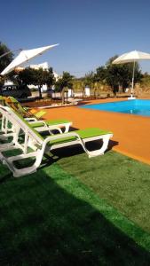 雷根古什-迪蒙萨拉什Reguengos Hotel的一组草坪椅,坐在游泳池旁