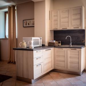 拉莫拉CASA RAMAGIO'的厨房配有白色橱柜、水槽和微波炉