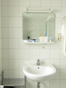 蒂索Uns Gartenhus mit Blick auf das Meer的白色的浴室设有水槽和镜子