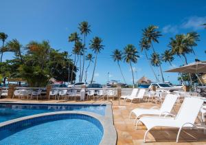 马拉戈日铺萨达奥赫笛阿瓜酒店的一个带桌椅的游泳池,棕榈树