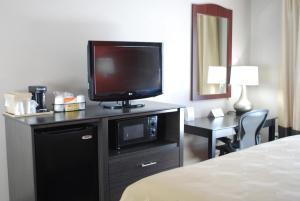 弗雷斯诺Quality Inn & Suites Fresno Northwest的酒店客房,配有带床铺的梳妆台,电视