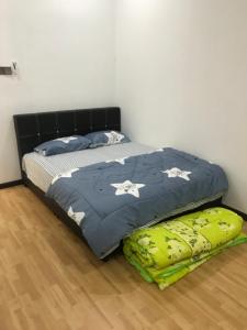 哥打巴鲁NRL's Cozy Guesthouse的卧室内的一张床铺,铺有木地板