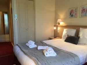 希农贝斯特韦斯特法兰西酒店的酒店客房的床上配有2条毛巾