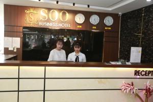 北宁巴克宁苏酒店的两人站在一家商务酒店的柜台