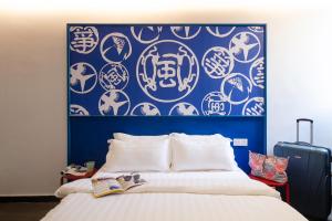 吉隆坡Kitez Hotel & Bunkz的卧室设有蓝色和白色的墙壁和一张床