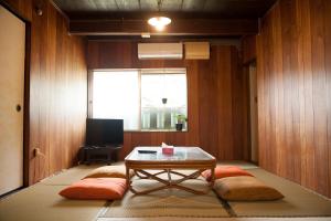 Shimo-yugeGuest House tokonoma的客厅配有一张桌子和两个软垫