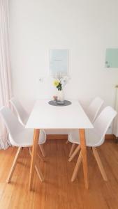 拉恩河畔林堡Apartment Am Paradies - 10 Minuten Fußweg zur Innenstadt的白色的桌子,白色的椅子和花瓶