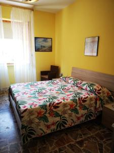 托里诺迪桑格罗vacanze al Mare appartamento in villa的一间卧室配有一张带彩色床罩的床