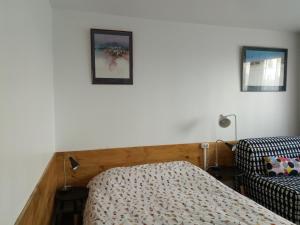 沙朗通勒蓬Charenton Home的卧室配有一张床,墙上挂有两张照片