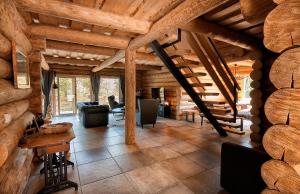 德雷兹尼克格雷德WOODS LODGE PLITVICE LAKES的大型客厅设有木制天花板和楼梯。