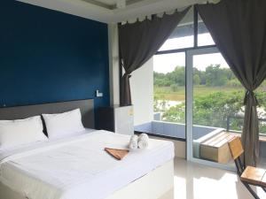 Takua PaNava Tara Resort的一间卧室设有一张大床和一个大窗户