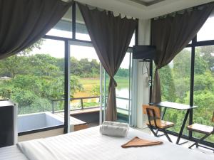 Takua PaNava Tara Resort的一间卧室设有一张床和一个大窗户