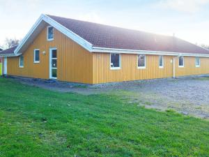 诺德堡12 person holiday home in Nordborg的前面有一片草地的大型橙色建筑
