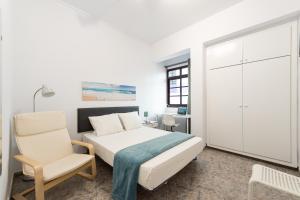 大加那利岛拉斯帕尔马斯CoolivingC的白色卧室配有床和椅子