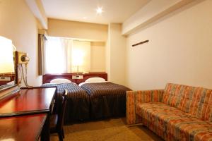 大阪永明酒店的酒店客房,配有床和沙发