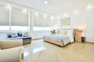 雅典AEOLIS SUITES的一间卧室配有一张床、一张沙发和窗户。