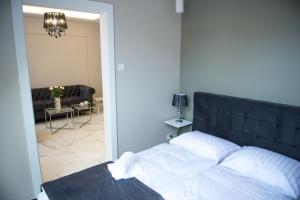 科沙林Apartamenty Prestiż 91的一间卧室设有一张床和一间客厅。