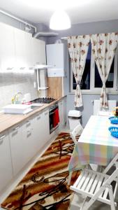 克卢日-纳波卡Ultra Central - Stunning Two Bedroom Apartment的厨房配有白色橱柜和桌椅