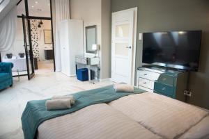 科沙林Apartamenty Prestiż 92的一间卧室配有一张大床和一台平面电视