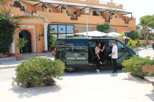 兰佩杜萨美杜莎酒店的两个人正在走出一辆绿色面包车