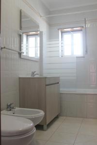 巴勒尔Baleal Holiday House的一间带水槽、卫生间和镜子的浴室