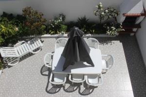 巴勒尔Baleal Holiday House的一张白色的桌子和椅子,上面有黑色的帽子