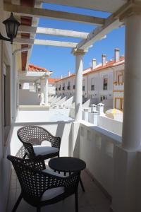 巴勒尔Baleal Holiday House的阳台的天井配有2把椅子和1张桌子