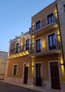 帕基诺Saint George's House Appartamenti & Spa的黄色的建筑,旁边设有阳台