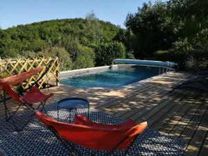 卡奥尔Chez Karine et Julien的一个带两把椅子的游泳池,甲板上设有吊床