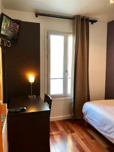 巴黎卢克瑟尔德酒店的一间卧室配有一张桌子、一张床和一个窗户