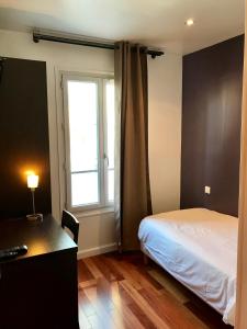 巴黎卢克瑟尔德酒店的一间卧室配有一张床、一张书桌和一个窗户。