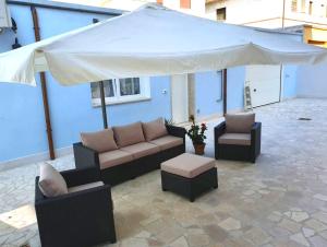 佩斯卡拉B&B Locanda Criloro的一个带沙发和大白伞的庭院