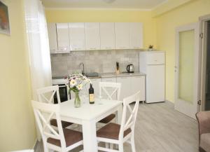 蒂瓦特Apartments Mira的厨房配有白色桌子和花瓶