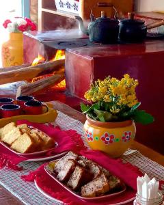 拉夫拉斯诺瓦斯Vila das Artes Chales的一张桌子,上面有一盘食物和花瓶